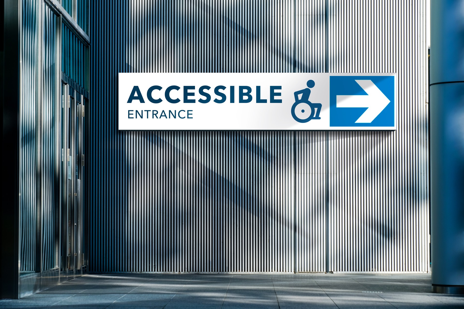 Accessible Entrance Sign on the exterior of a building with an arrow pointing to the entrance